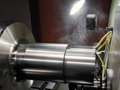 Roll turning in a lathe chuck under coolant spray